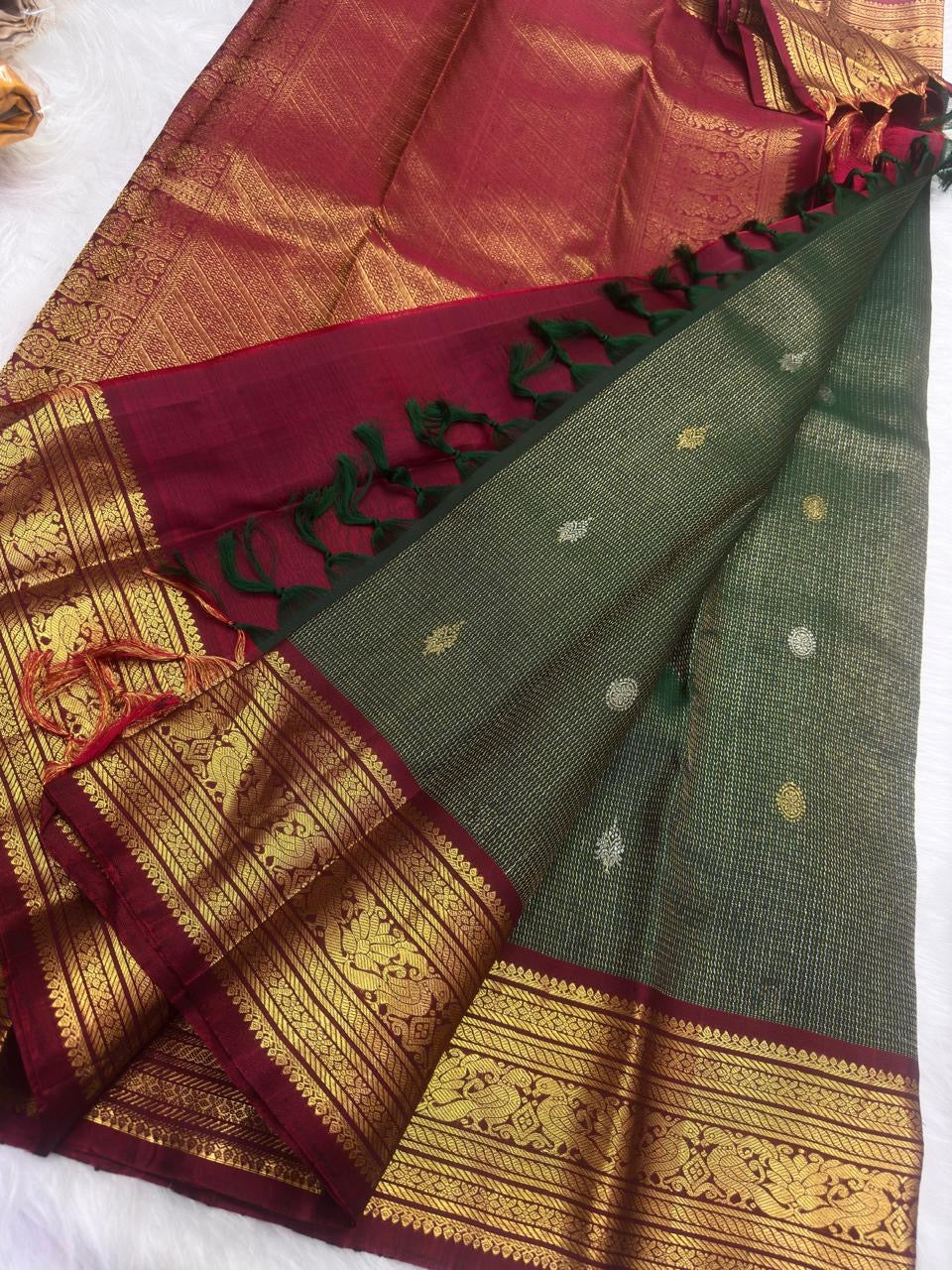 Fine Zari Kattam texture and scattered buttas on the deep Adar Pachai green silk.