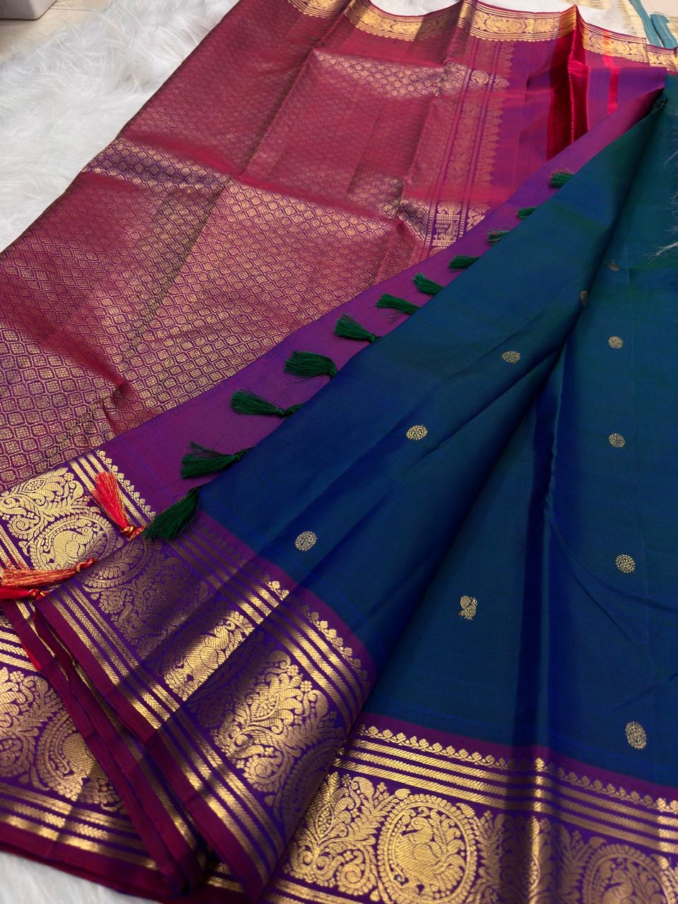Deep Kadal Neelam Blue Pure Silk Kanchipuram Butta saree with gold buttas and Vadamalli zari border.
