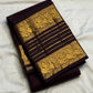 Deep brown Kanchipuram silk saree with spaced gold zari buttas and layered Varisaipet border.
