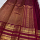 Handwoven deep magenta Varisaipet saree with spaced antique-gold zari motifs.
