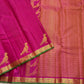 Folded deep magenta Kanchi Pattu pure silk saree showing Vairaoosi zari shimmer body and green contrast border