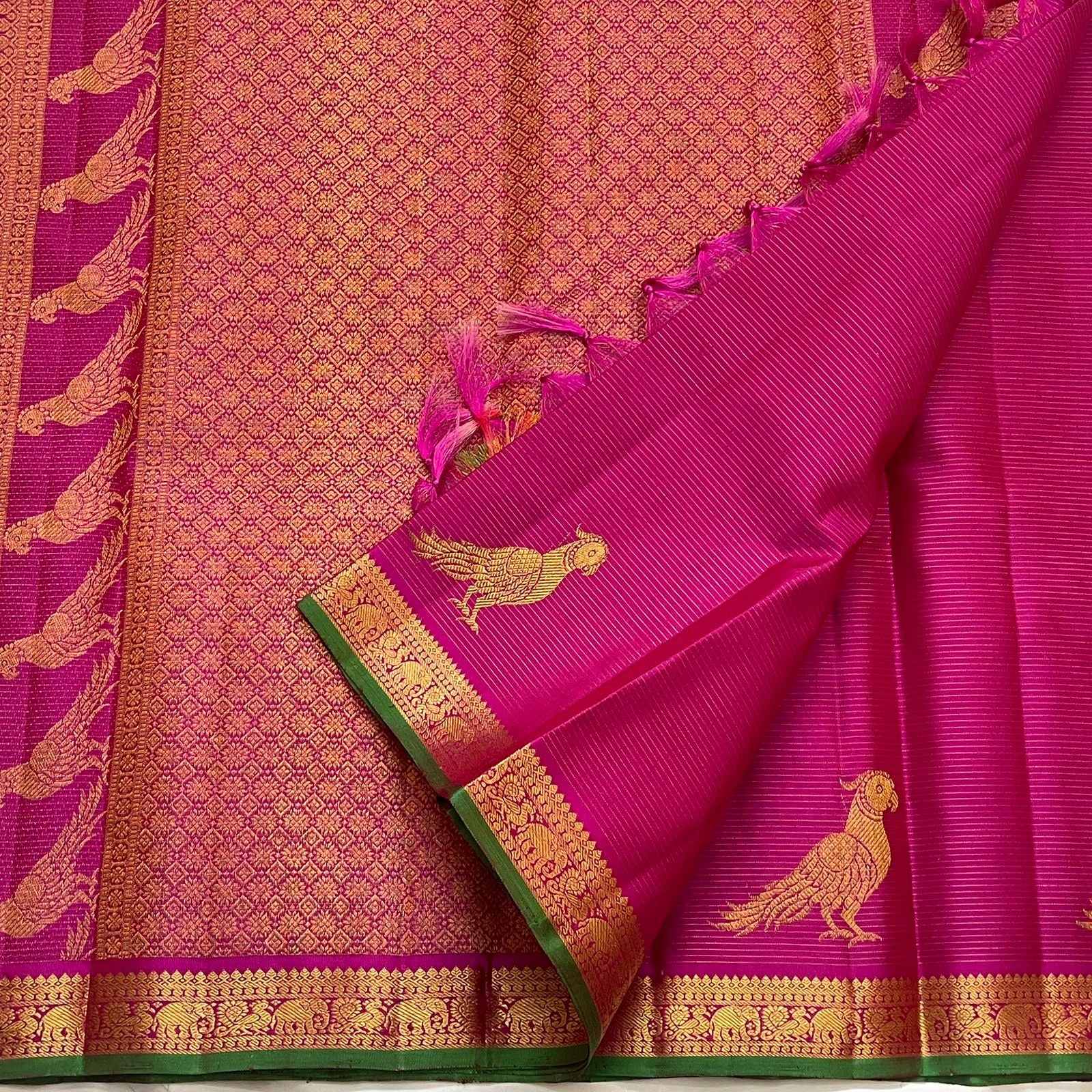 Ornate peacock Kili Butta gold zari pallu of deep magenta Kanchi Pattu saree on green ground