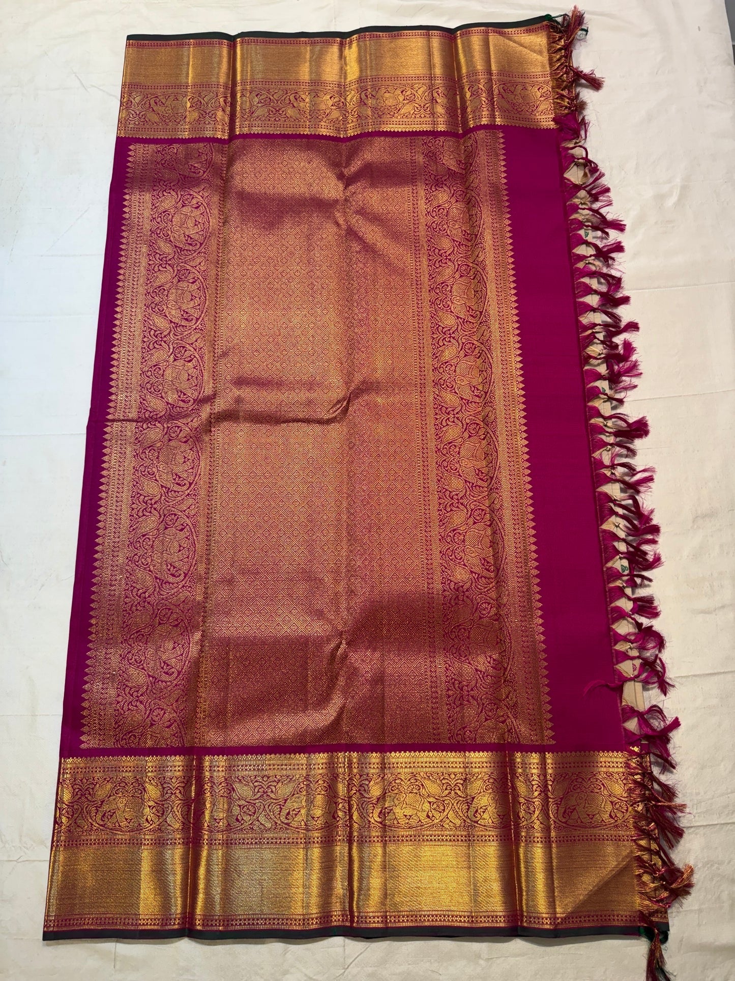 Full pallu view of the Deep Magenta zari pallu with dense woven gold detailing and contrast edge