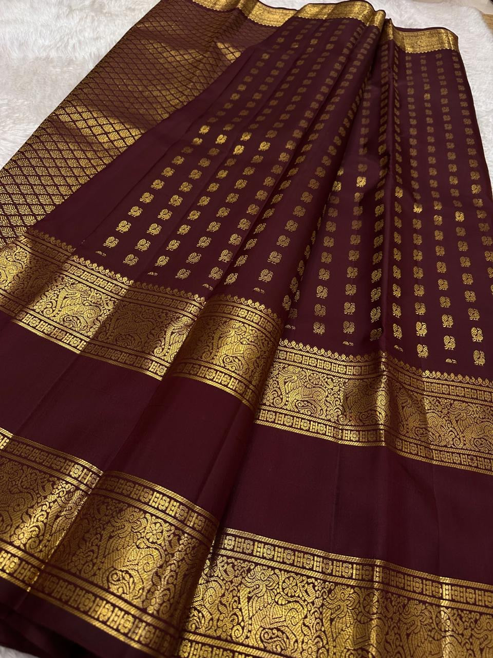Deep maroon Kanjipuram silk body close-up showing ambari yaanai elephant butta motifs