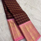 Pink border woven with gold-zari peacock and elephant motifs on deep maroon Kanchipuram silk.