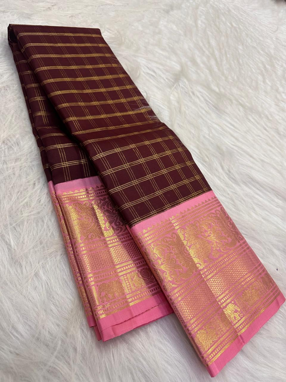 Pink border woven with gold-zari peacock and elephant motifs on deep maroon Kanchipuram silk.
