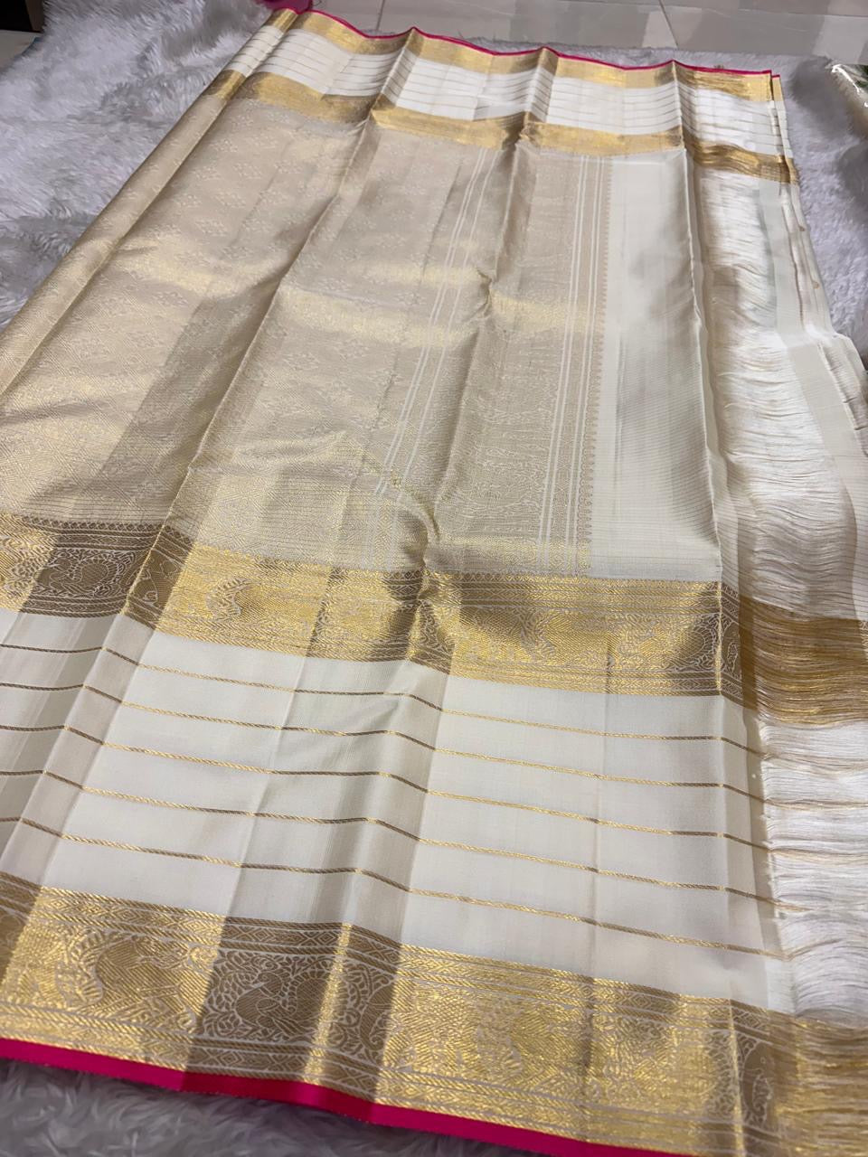 Warm Ivory Kanjivaram pallu with dense antique-gold geometric and ornamental weaving.
