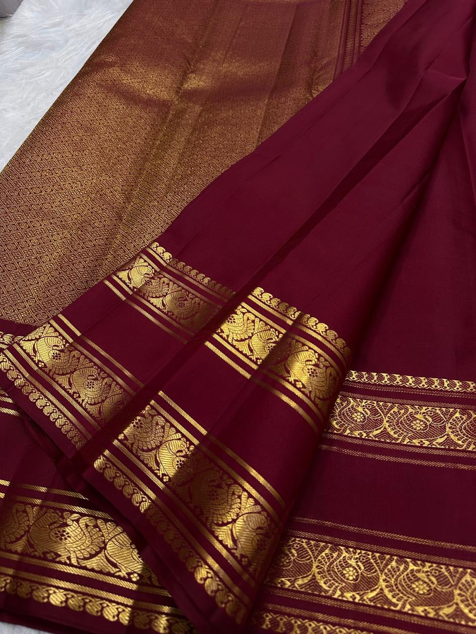 Deep maroon Rettapet saree with mango buttas and Annam border, folded view