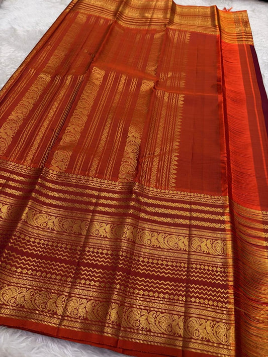 Rust orange Varisaipet border with red silk thread woven motifs on deep maroon Kanchipuram saree