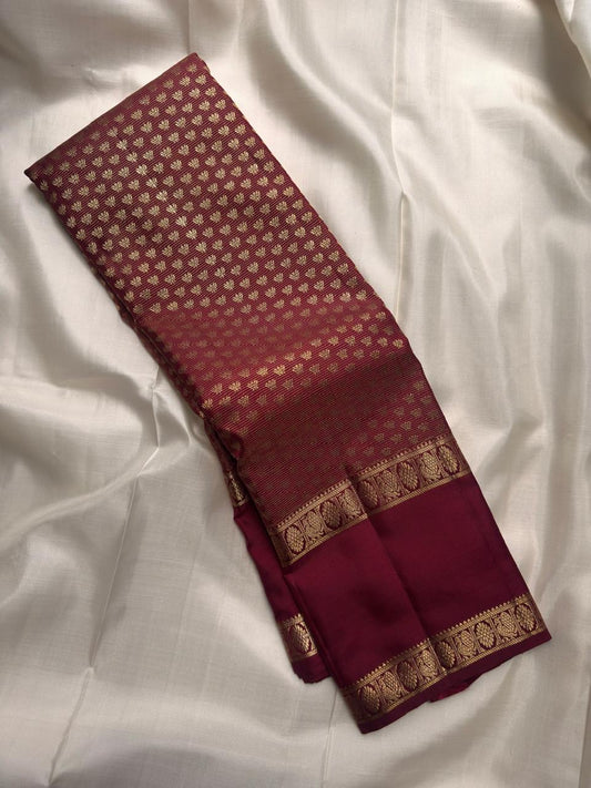 Dense antique-gold Kanchipuram pallu showing a fine geometric zari field against deep garnet silk.