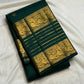 Deep green Kanchipuram silk saree with spaced gold zari buttas and layered Varisaipet border.