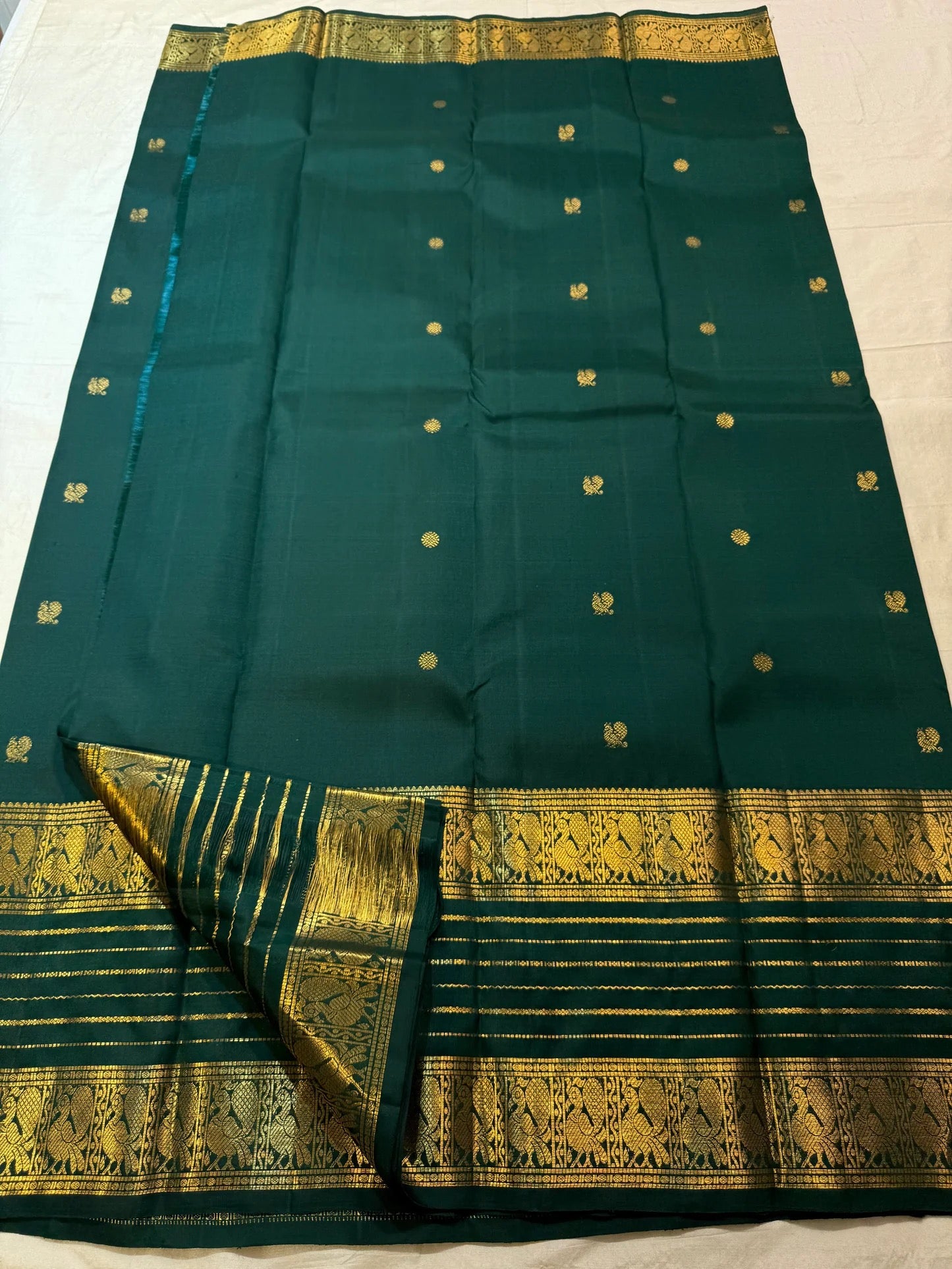 Deep Pachai Green pure silk Kanjivaram Varisaipet saree with radiant warm gold zari border.