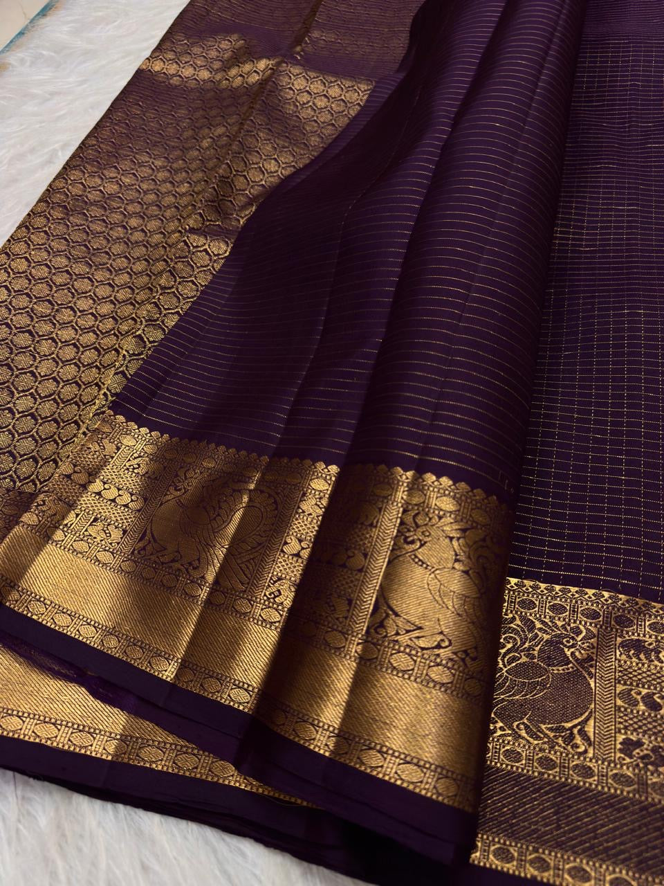 Close view of antique-gold traditional buttas on Deep Aubergine Purple Kanjivaram silk.