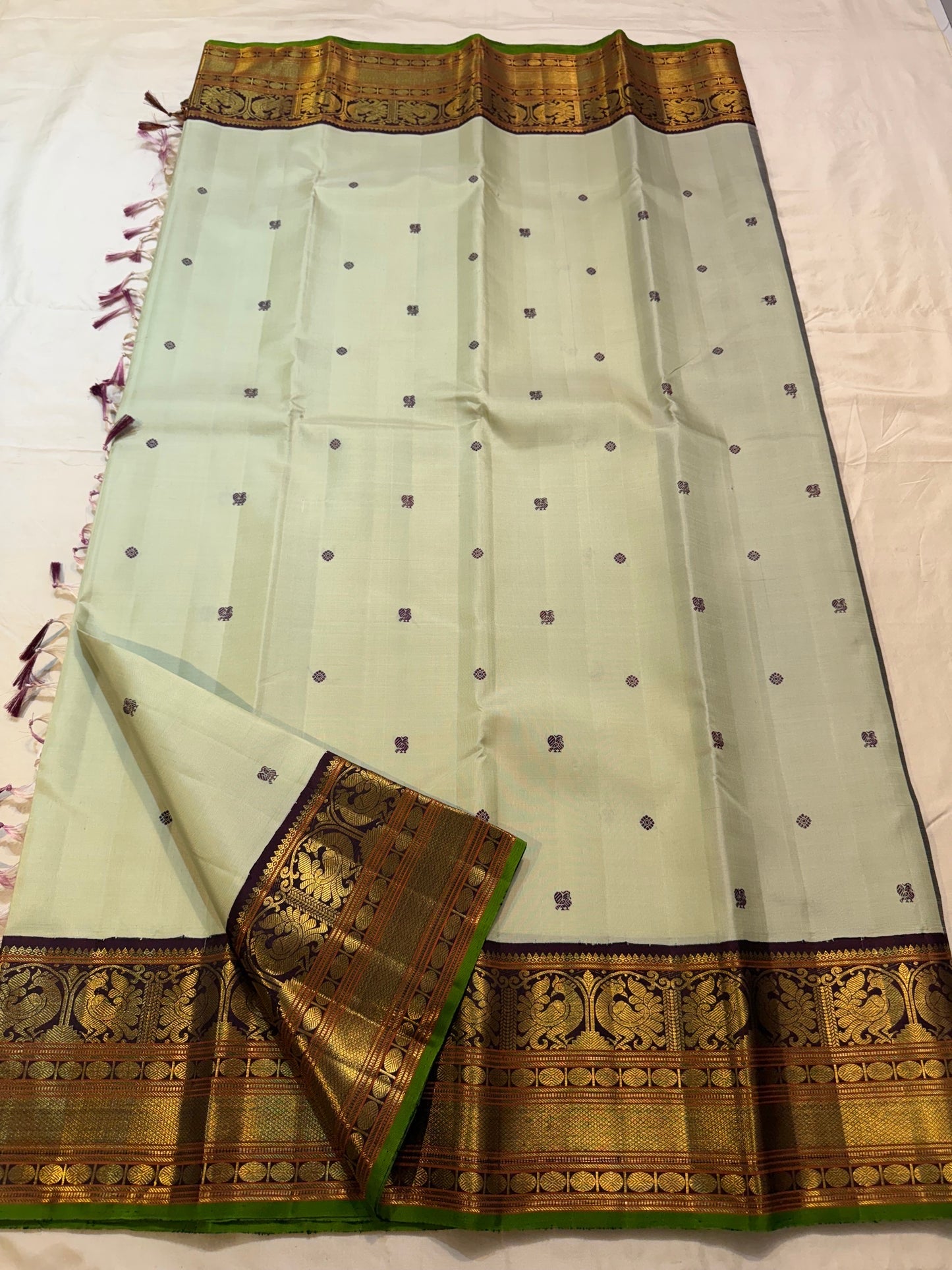 Deep purple Kanchana border with dense gold zari peacock panels on pistachio green saree — Idam Living