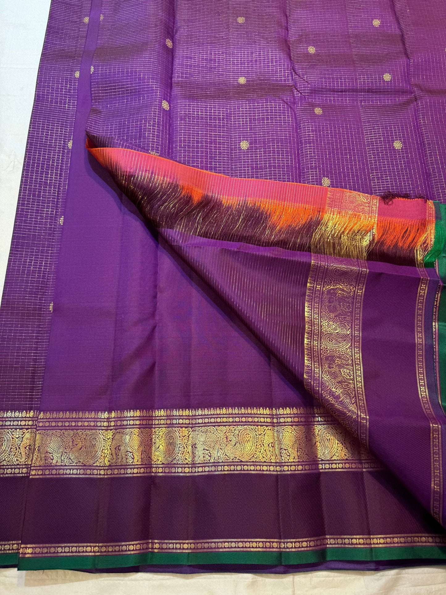 Kanchana Purple Kanchi Pattu border with gold zari ornament and emerald-green finishing edge.