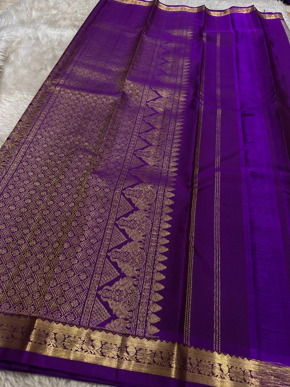 Full pallu spread in purple with gold zari woven grid pattern and a decorative motif panel beside the border, shipped from New Jersey USA.