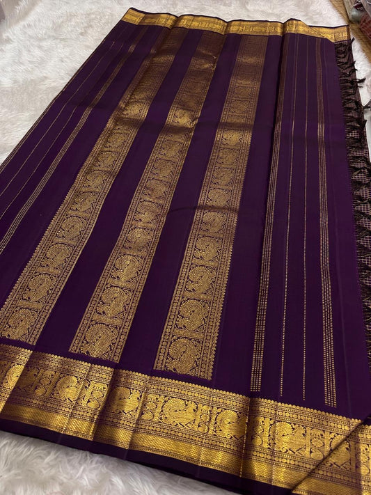 Deep purple Kanjipuram Zari Kattam saree folded flat showing luminous gold check weave and grand border — Idam Living