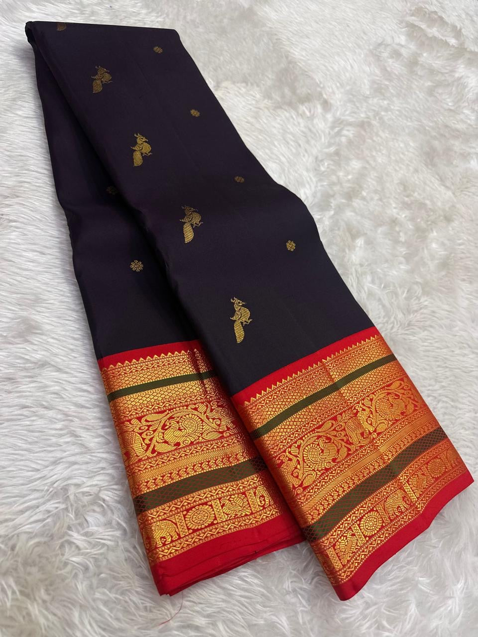 Handwoven Kanchipuram Korvai saree with vermillion red and gold zari border detail