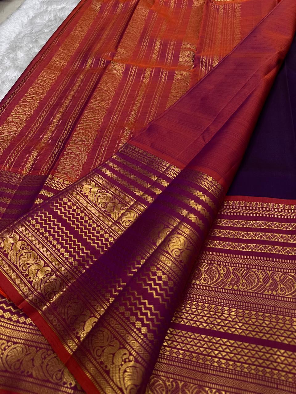 Rust orange Varisaipet border with red silk thread woven motifs on deep purple Kanchi Pattu saree