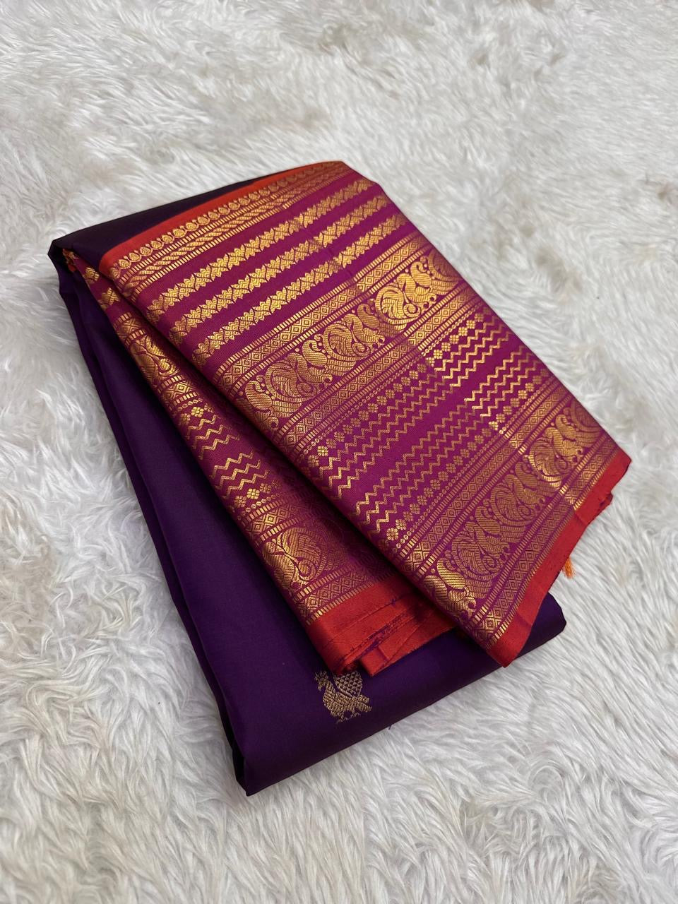 Rust orange pallu with red silk thread motifs on deep purple Varisaipet Kanchi Pattu saree