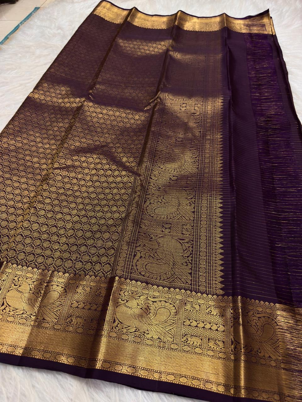 Grand Mayil peacock border in antique gold on Deep Purple Kanjivaram saree.