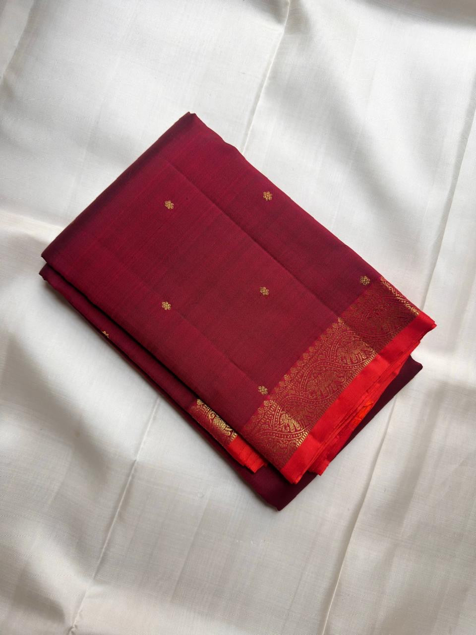 Deep Raspberry Maroon handwoven pure silk Kanjivaram Butta saree with antique-gold zari buttas.