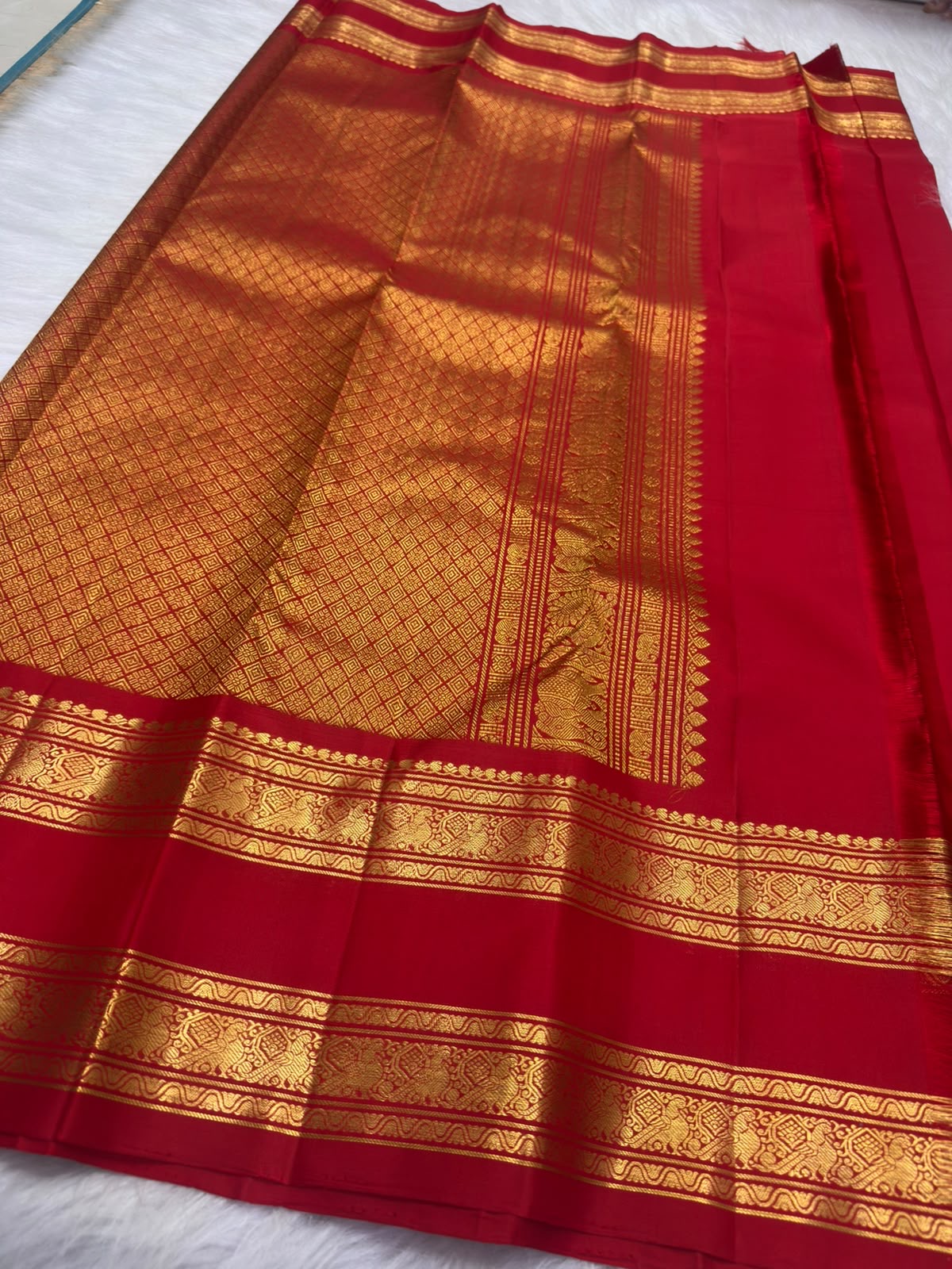 Deep raspberry pink handwoven Kanjipuram Rettapet saree, folded view with gold zari buttas