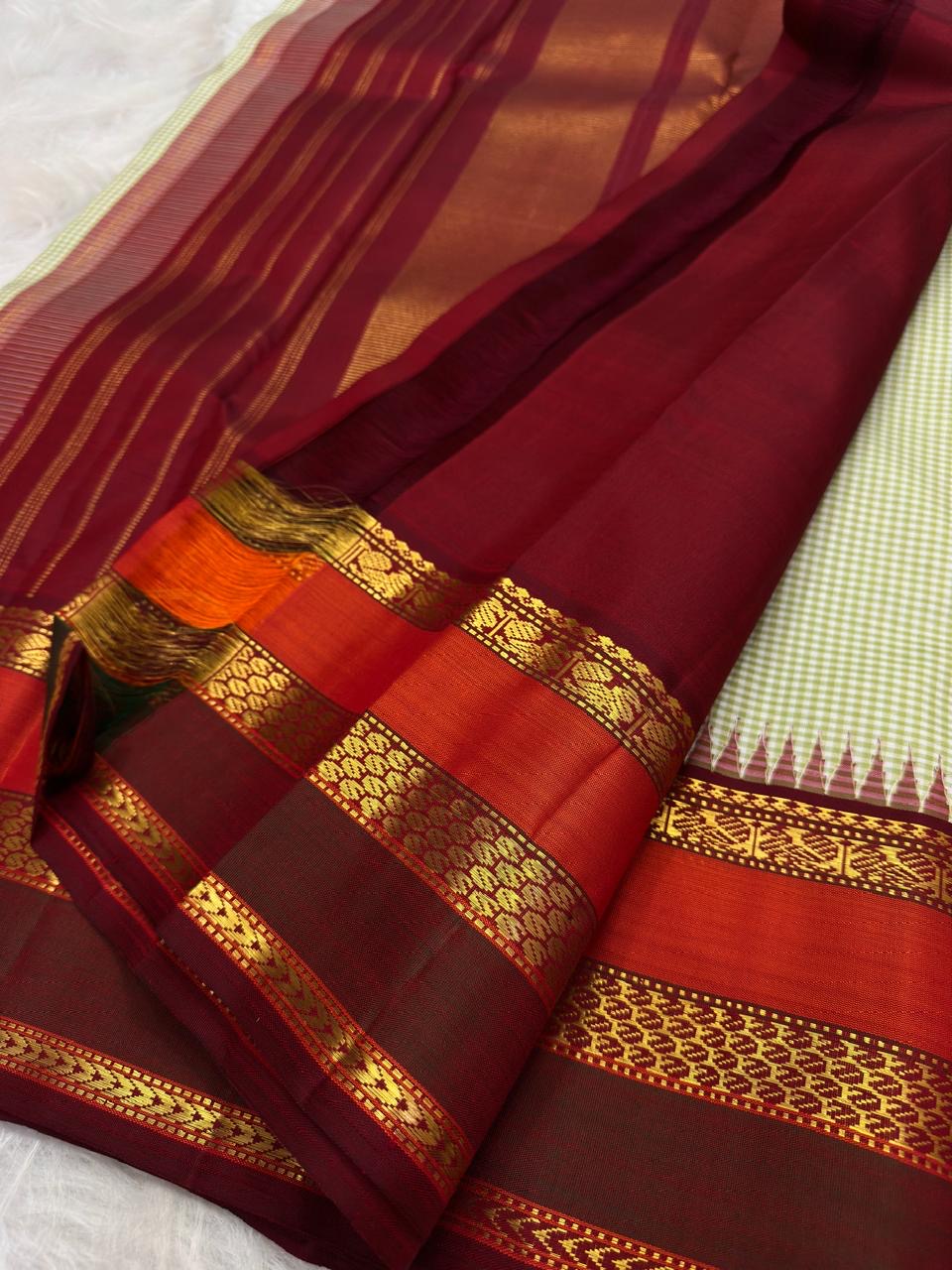 Close view of geometric and ornamental gold zari detailing in the Varisaipet border.
