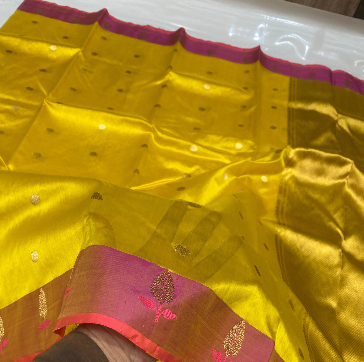 Turmeric yellow Chanderi saree with scattered gold-toned buttas and raspberry pink border with small motifs