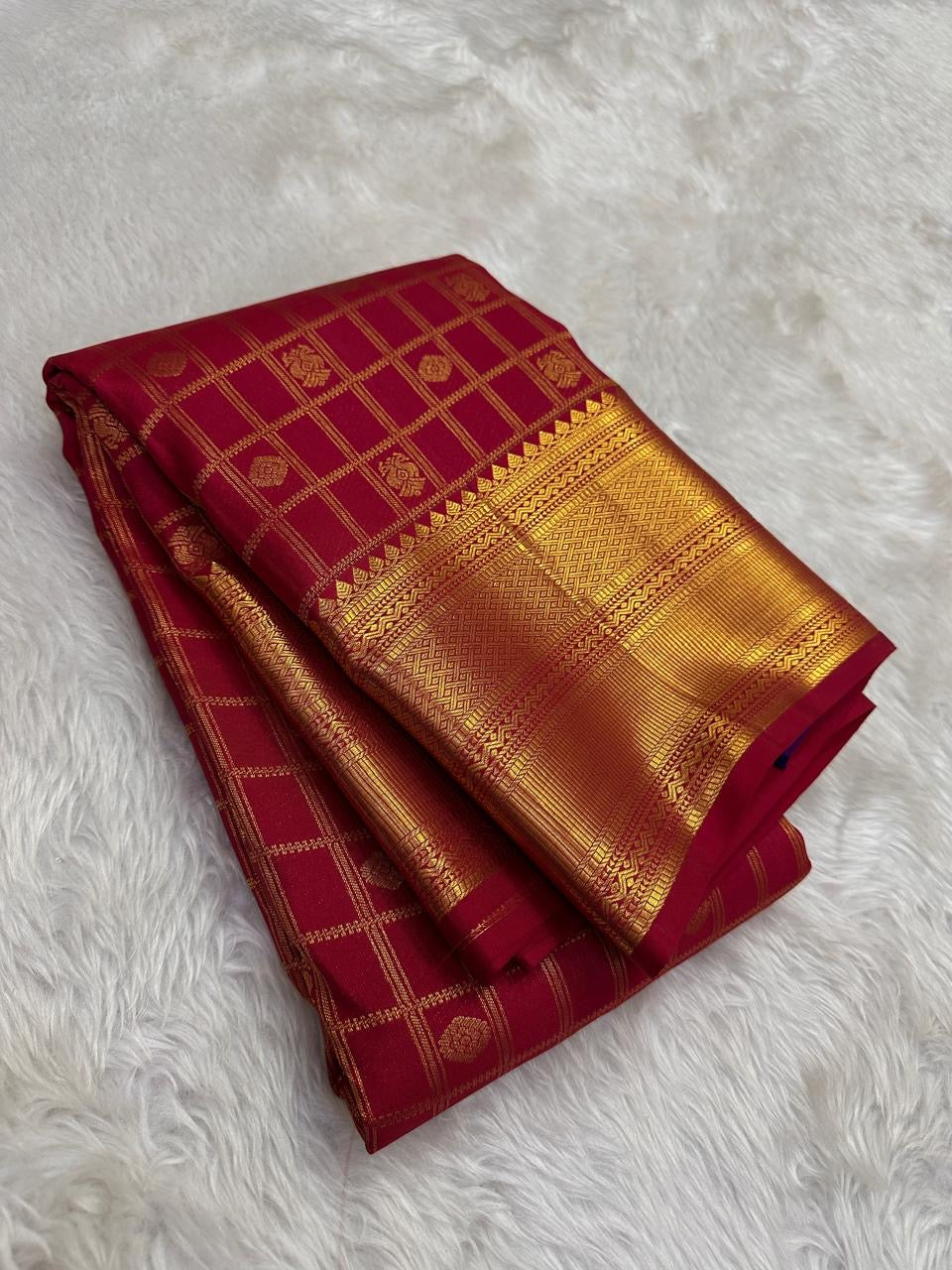Folded view of deep rose red pure silk Kanchipuram saree with Zari Kattam Gandaberunda Butta