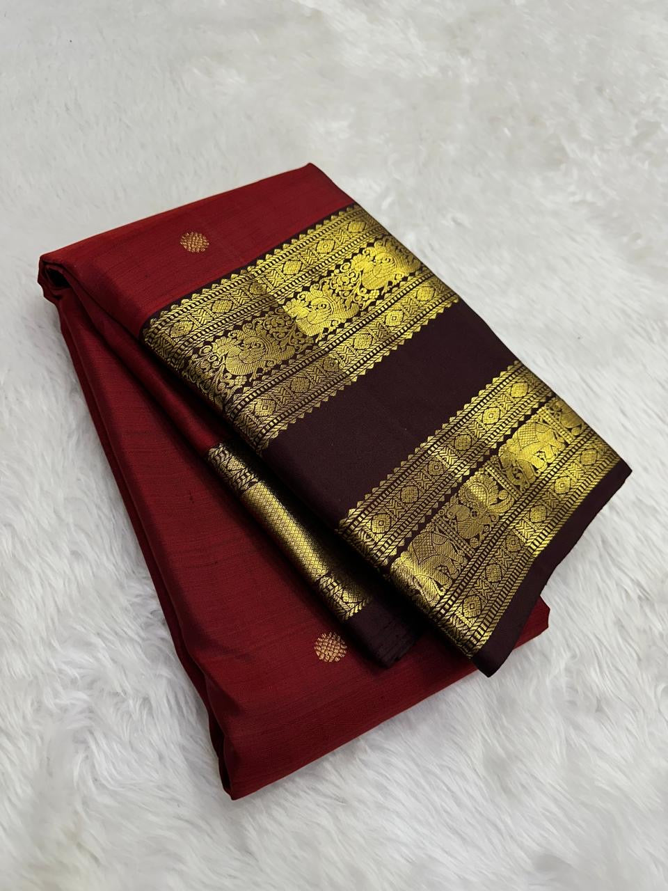 Deep vermilion red Kanjivaram silk saree body close-up with gold zari buttas