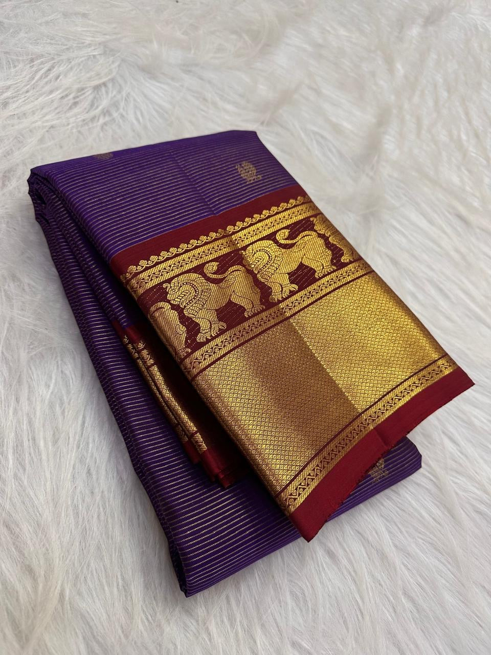 Folded Deep Violet Vaira silk showing fine metallic lines and lined-up Yazhi motifs across the gold zari border.