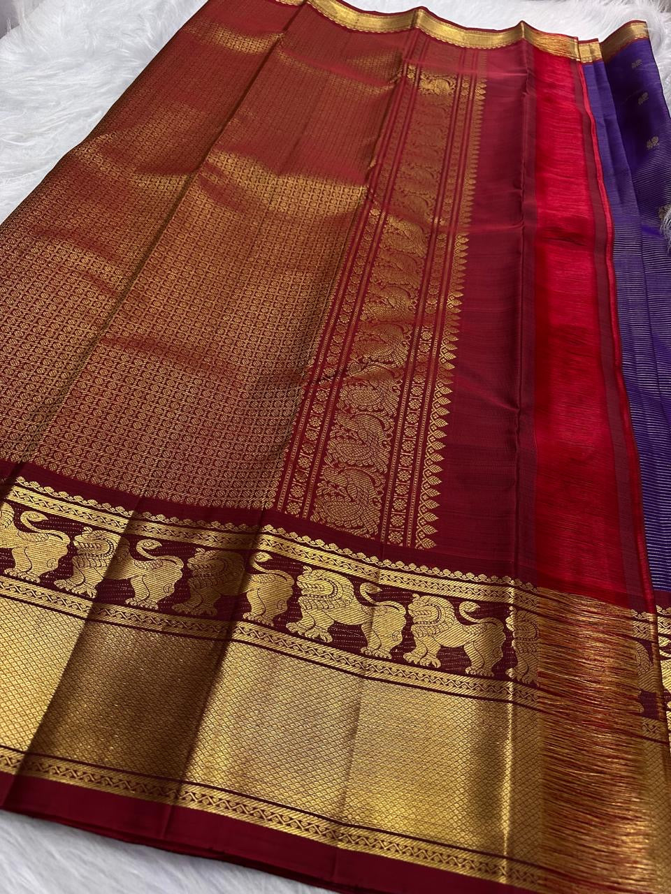 Close view of handwoven Yazhi zari border with broad gold field beside Deep Violet Vaira silk.