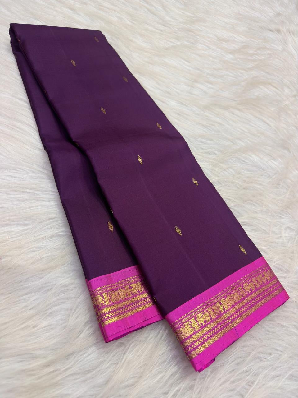 Handwoven Butta KanchiPattu saree in deep violet with small gold zari motifs across the body.