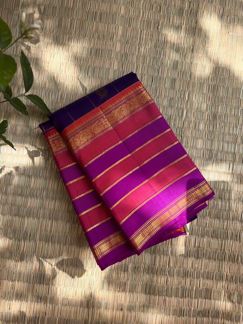 Deep violet Kanchipuram silk body with fine classic-gold zari grid lines and individually spaced zari buttas.