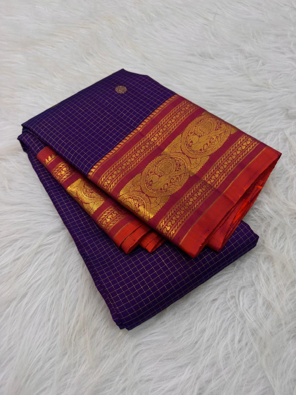 Full view of a deep violet Kanjivaram Zari Kattam silk saree with a burnished vermilion Sorgavaasal Mayil border