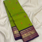 Close view of Parrot Green Korvai silk with detailed Mayil zari border, Rani Pink accents and ornate gold registers.