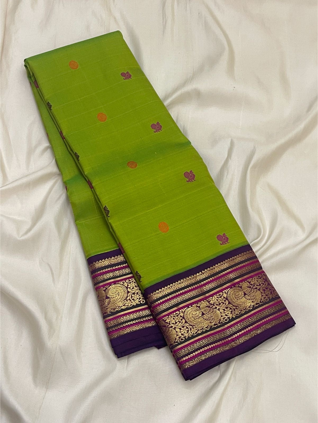 Close view of Parrot Green Korvai silk with detailed Mayil zari border, Rani Pink accents and ornate gold registers.