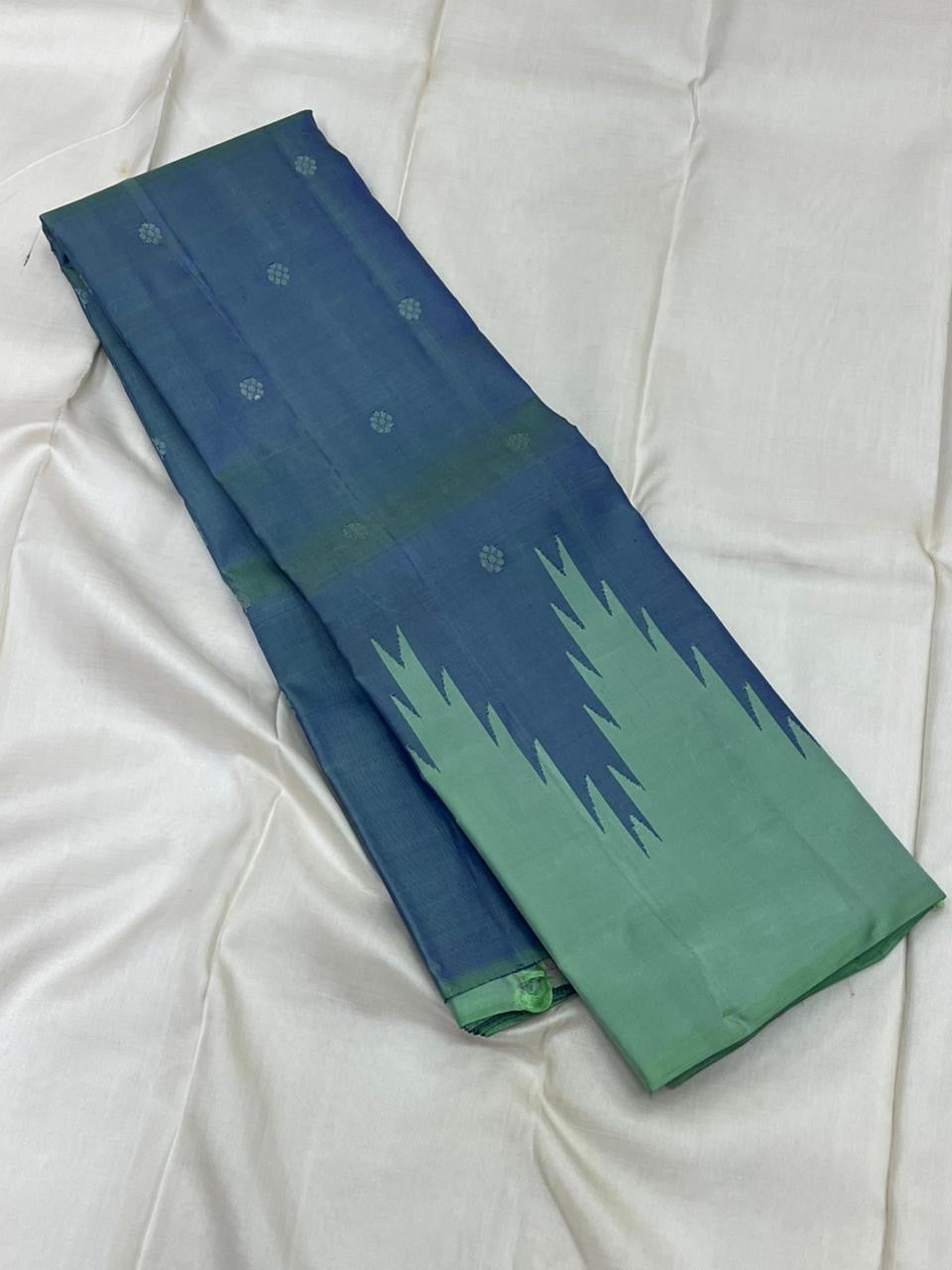 Flat-lay Pure Kanchipuram silk saree showing deep blue field with small motifs and mint striped section, shipped from New Jersey USA