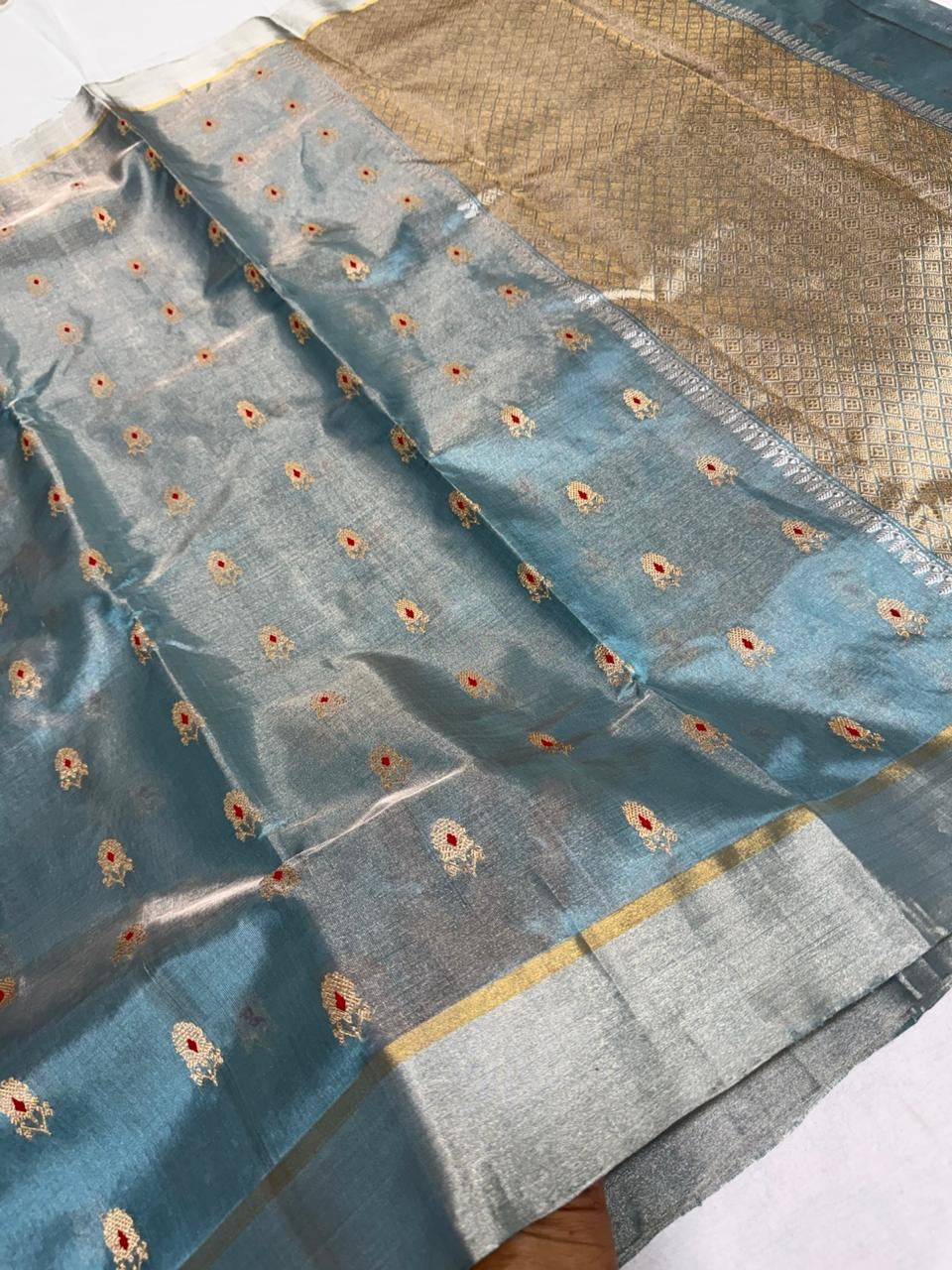 Dusty blue Tissue Pattu Silk Chanderi displayed with silver border, fine gold edging and metallic woven pallu