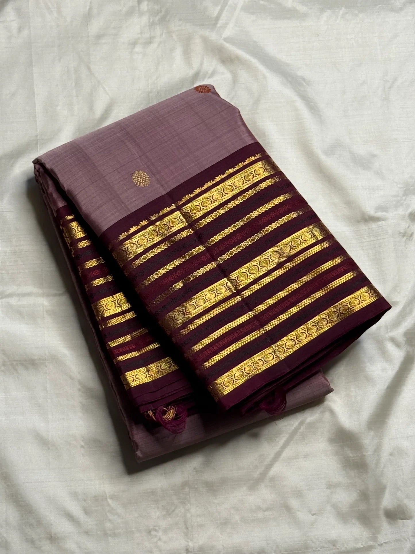 Close-up of silk thread butta in orange and gold on dusty brown-purple mauve Kanchipuram silk saree — Idam Living