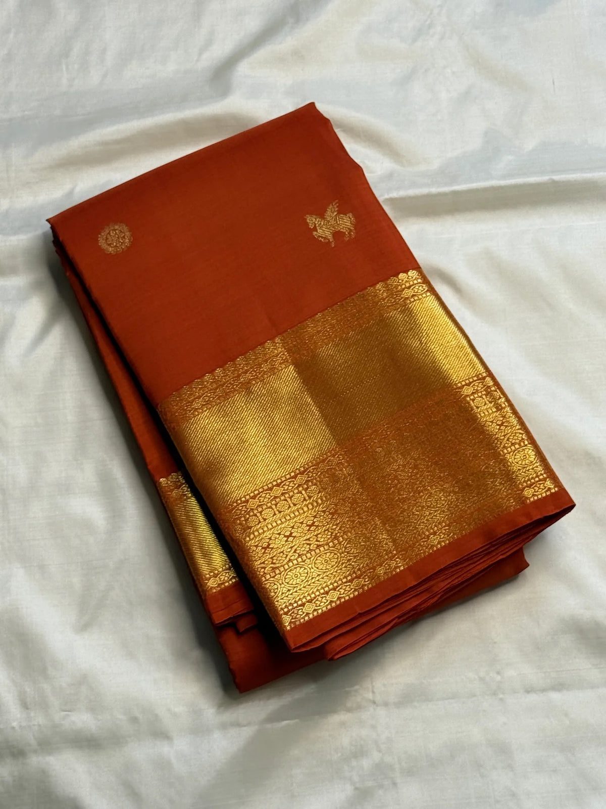 Earthy burnt-orange handwoven Pure Silk Kanjivaram Butta saree with gold zari buttas
