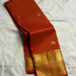 Full view of the earthy burnt-orange Pure Silk Kanjivaram Butta saree with broad gold zari border