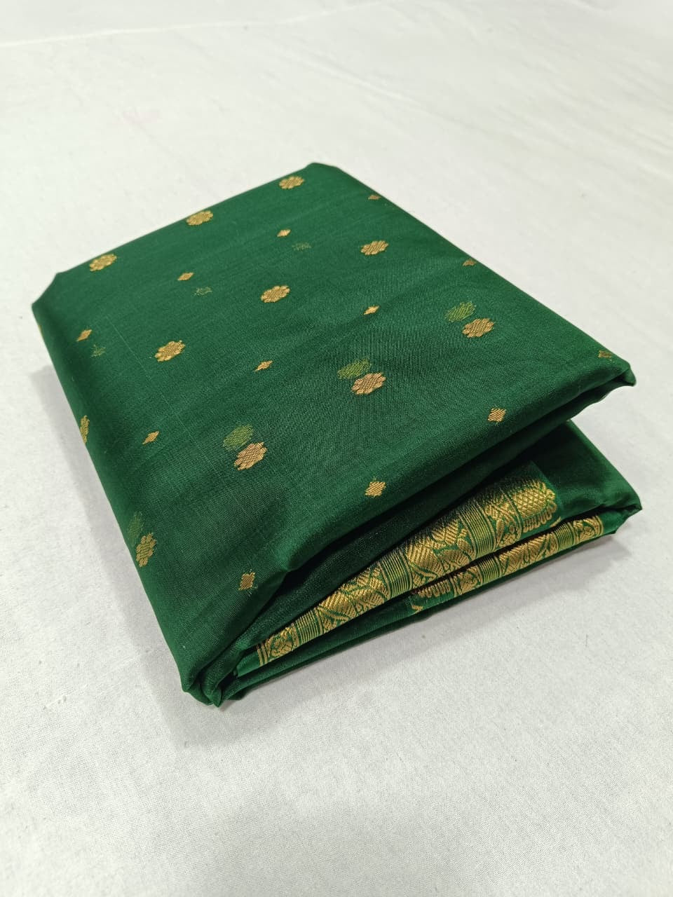 Emerald Green Chanderi Katan Silk saree displayed to show the jewel-toned green silk body and gold zari border