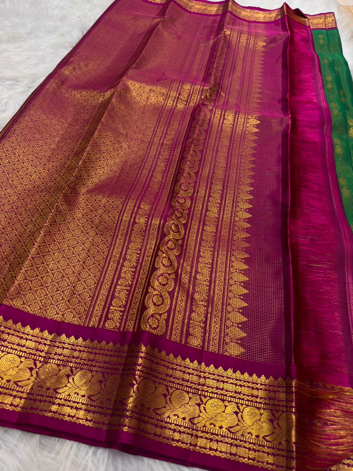 Gold zari lines catching light on emerald-green KanchiPattu saree