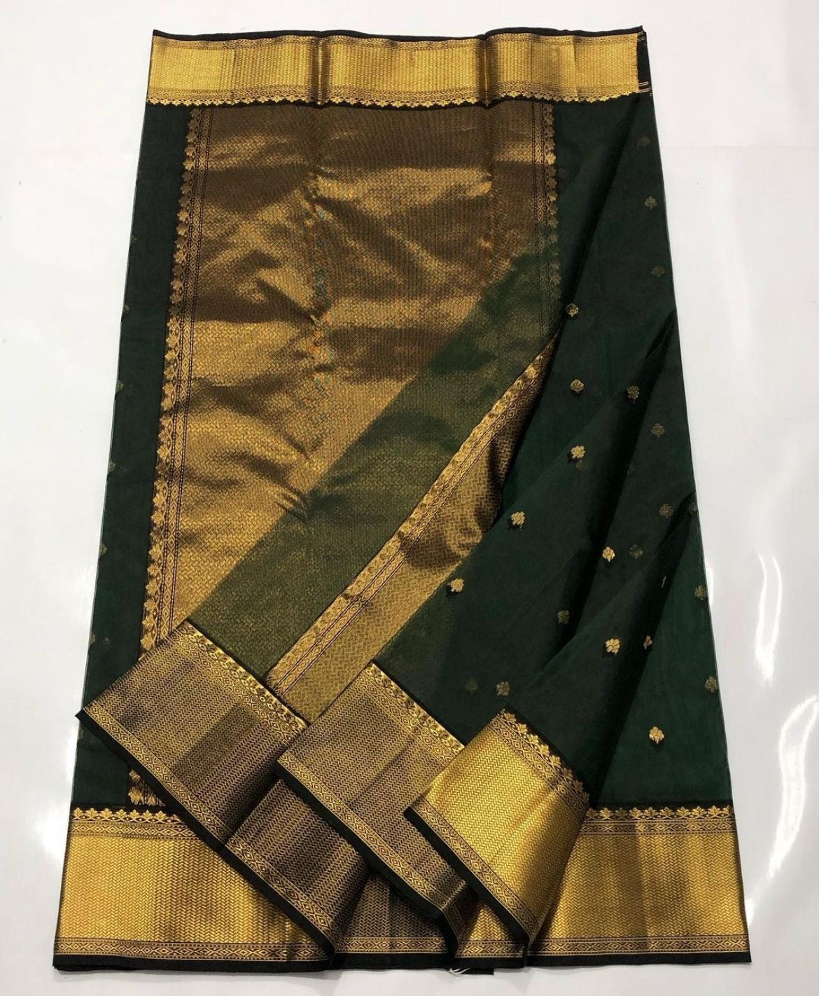 Deep Emerald Green Katan Silk Chanderi saree showing the broad antique-gold woven border with geometric and floral detailing.