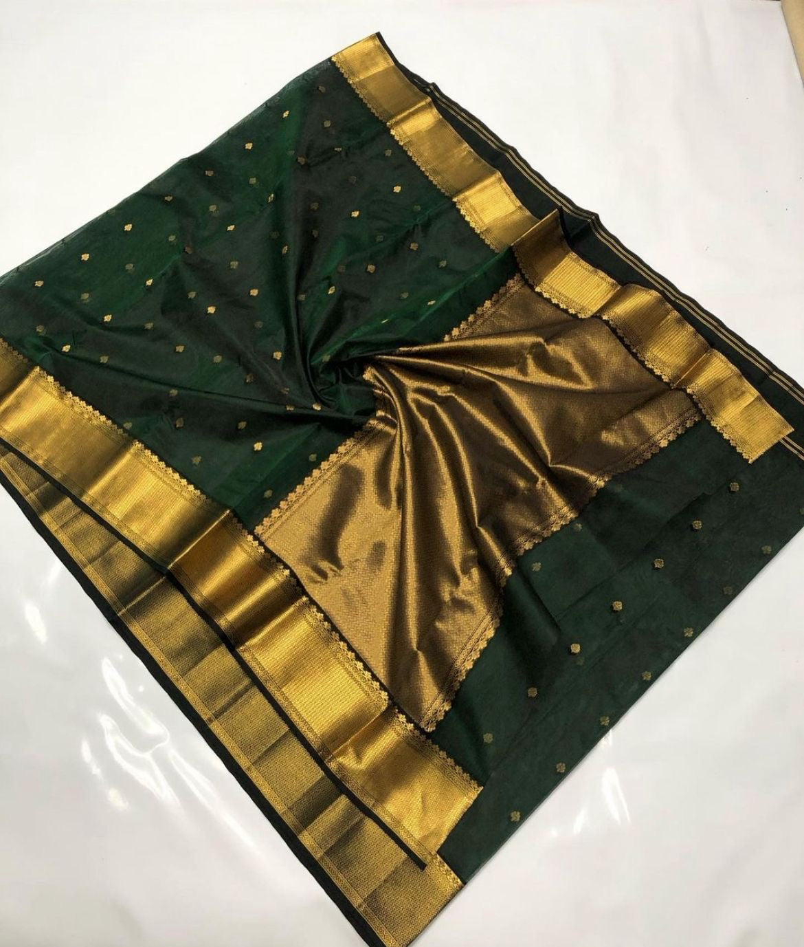 Deep Emerald Green Katan Silk Chanderi saree with scattered gold floral buttas, broad antique-gold border and woven gold pallu.