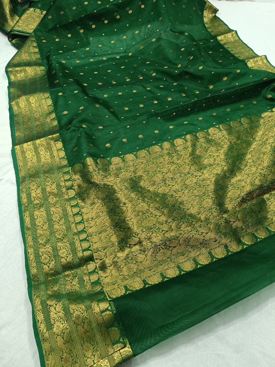 Emerald Green Pure Silk Chanderi saree arranged to show the emerald body and woven gold accents