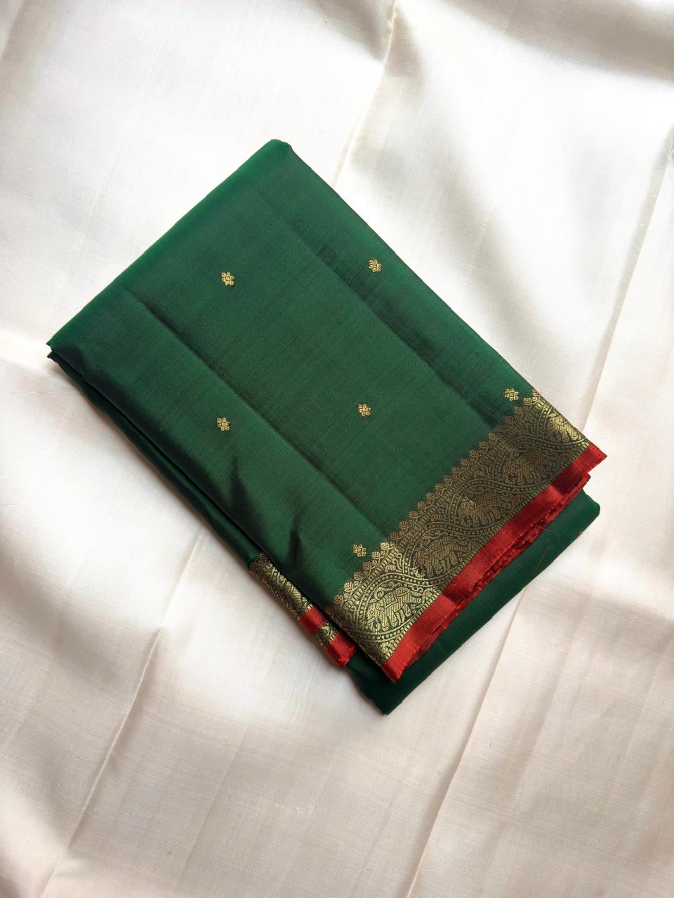 Deep Emerald Green pure silk Kanchipuram saree with antique-gold woven detailing.