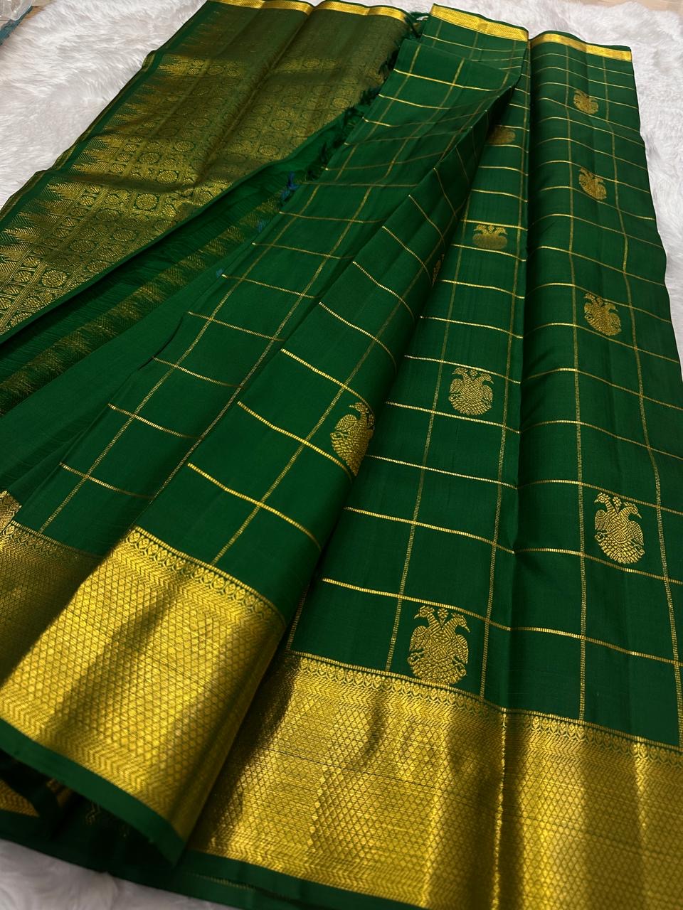 Deep emerald green pure silk Kanchipuram saree with gold Zari Kattam checks, handwoven Gandaberunda motifs and broad antique gold zari border.